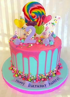 a birthday cake decorated with candy, lollipops and candies for two year old