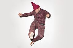 a man in pajamas and a red hat is flying through the air