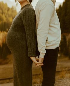 a man and woman holding hands while standing next to each other