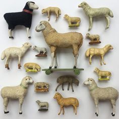 a collection of sheep and lamb figurines sitting on top of a white surface