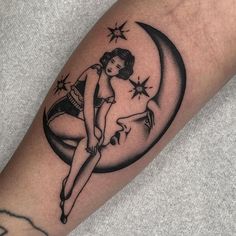 a woman is sitting on the moon with her legs crossed and stars flying in the sky