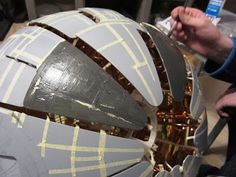 a person is working on a model of a space station in the process of being assembled