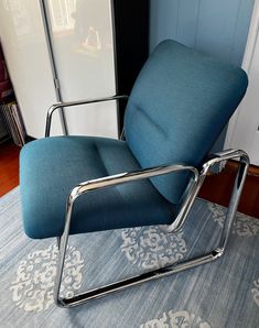 a blue chair sitting on top of a rug