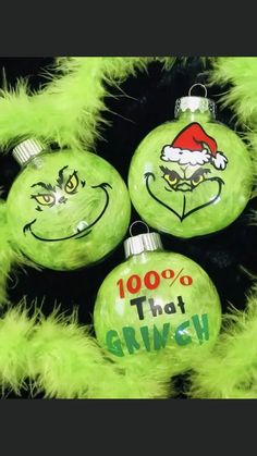 three green christmas ornaments with faces drawn on them and the words 100 % that grin