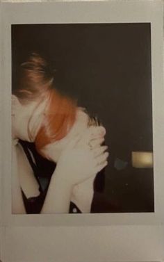 a polaroid photograph of a woman hugging her head