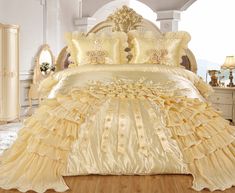 the bed is made up with yellow ruffles and gold trimmings on it