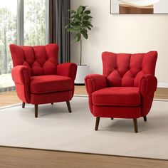 two red chairs sitting on top of a white rug