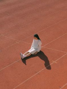 a woman sitting on the ground with her legs crossed