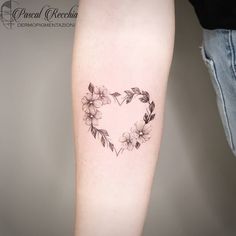 a woman's arm with a heart shaped flower tattoo on the left side of her leg