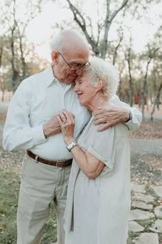 an older couple embracing each other in the park