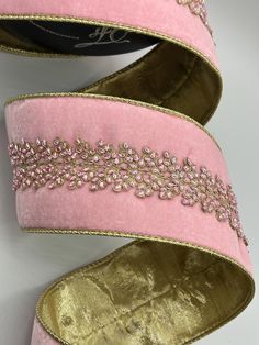 a pair of pink shoes with gold trims