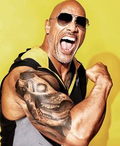 a bald man with sunglasses on his head and arm is flexing his muscles in front of a yellow background