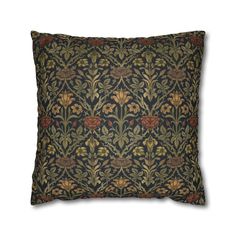 a black and gold pillow with an ornate design on the front, featuring leaves and flowers