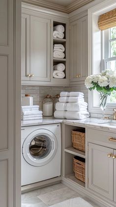 a washer and dryer in a room with lots of towels on the shelves