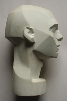 a white sculpture is on display against a gray background with the image of a human's head