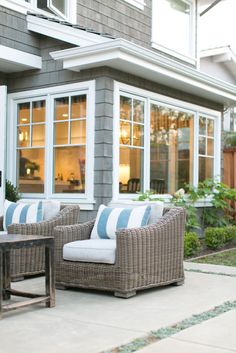 two wicker chairs sitting on top of a patio