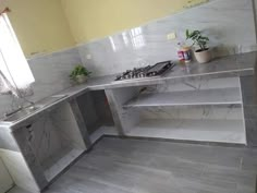 a kitchen with marble counter tops and shelves