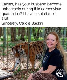 a woman sitting in front of a cage with a tiger on it's back