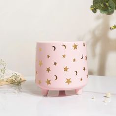 a pink planter with gold stars on it