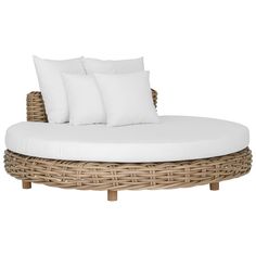 a wicker daybed with white pillows and two throw pillows on the top of it