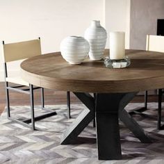 a round table with chairs around it and a vase on the table next to it