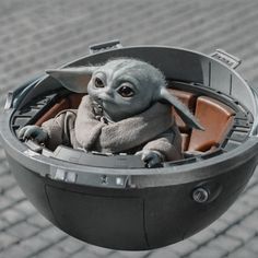 a baby yoda doll sitting inside of a metal container