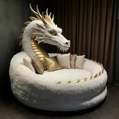 a white and gold dragon head sitting on top of a round bed in a room