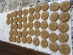 several cookies are arranged on a marble counter top and lined up against a white wall