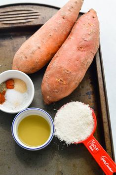 two sweet potatoes and some spices on a tray