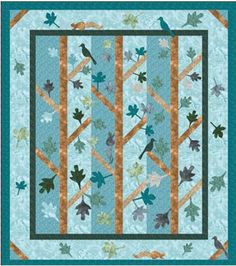 a blue quilt with leaves and birds on the front, along with a green border