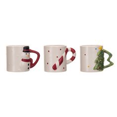 three coffee mugs with christmas decorations on them and one is holding a candy cane