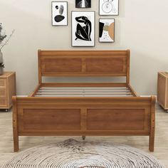 a wooden bed frame with drawers underneath and pictures on the wall above it in a bedroom