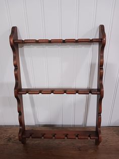 an old wooden shelf with several hooks on it