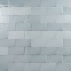 a white tiled wall in a bathroom