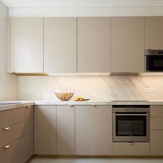 a kitchen with beige cabinets and marble counter tops