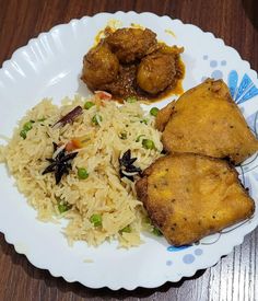 a white plate topped with rice and meat next to another plate filled with fried food