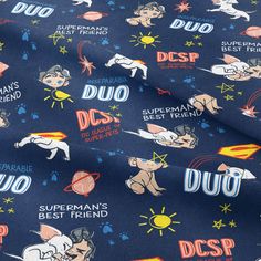 a blue fabric with cartoon characters and words on it, including the dcp logo