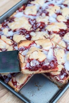 someone is cutting into a dessert on a pan with a spatula and knife in it