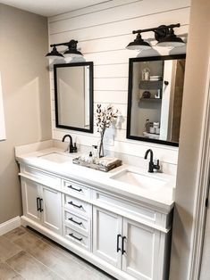 a bathroom with double sinks and two mirrors