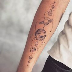 a man's arm with planets and stars on it