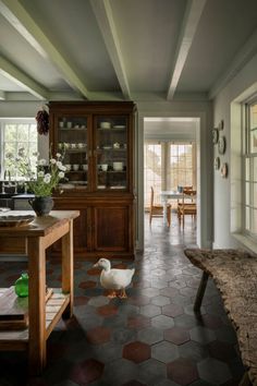 a duck is standing in the middle of a room with tile flooring and walls