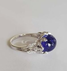 For Sale on 1stDibs - Dalben design white gold ring with an oval cabochon cut Tanzanite weight 8,70 carat and 44 white round brillant cut Diamonds weight 0,23 carats mounted Formal Polished Finish Oval Cabochon Sapphire Ring, Exquisite Formal Gemstone Cabochons, Fine Jewelry Sapphire Ring With Oval Cabochon, Oval Cabochon Sapphire Ring With Polished Finish, Formal Fine Jewelry Gemstone Cabochons, Luxury Cabochon Diamond Ring For Formal Occasions, Luxury Formal Cabochon Diamond Ring, Sapphire Cabochon Diamond Ring, Luxury White Gold Diamond Cabochons