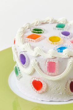 there is a cake that has been decorated with many different colored icing shapes on it