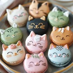 a plate filled with lots of different colored cat shaped cookies on top of each other