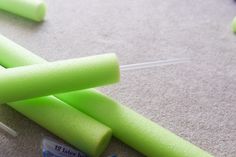 several green sticks are laying on the floor next to some toothbrushes and an eraser