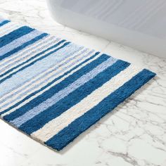 a blue and white bathroom rug on the floor