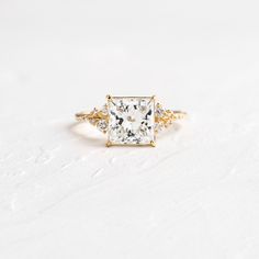 a white and yellow diamond ring with three diamonds on the band, set in 18k gold