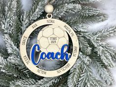 a wooden ornament with the word coach on it hanging from a christmas tree