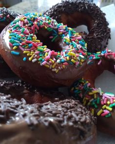 there are many donuts with chocolate frosting and sprinkles