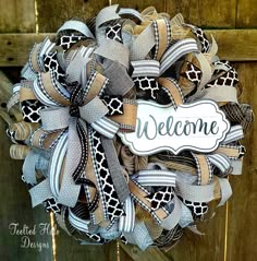 a welcome wreath is hanging on a wooden door